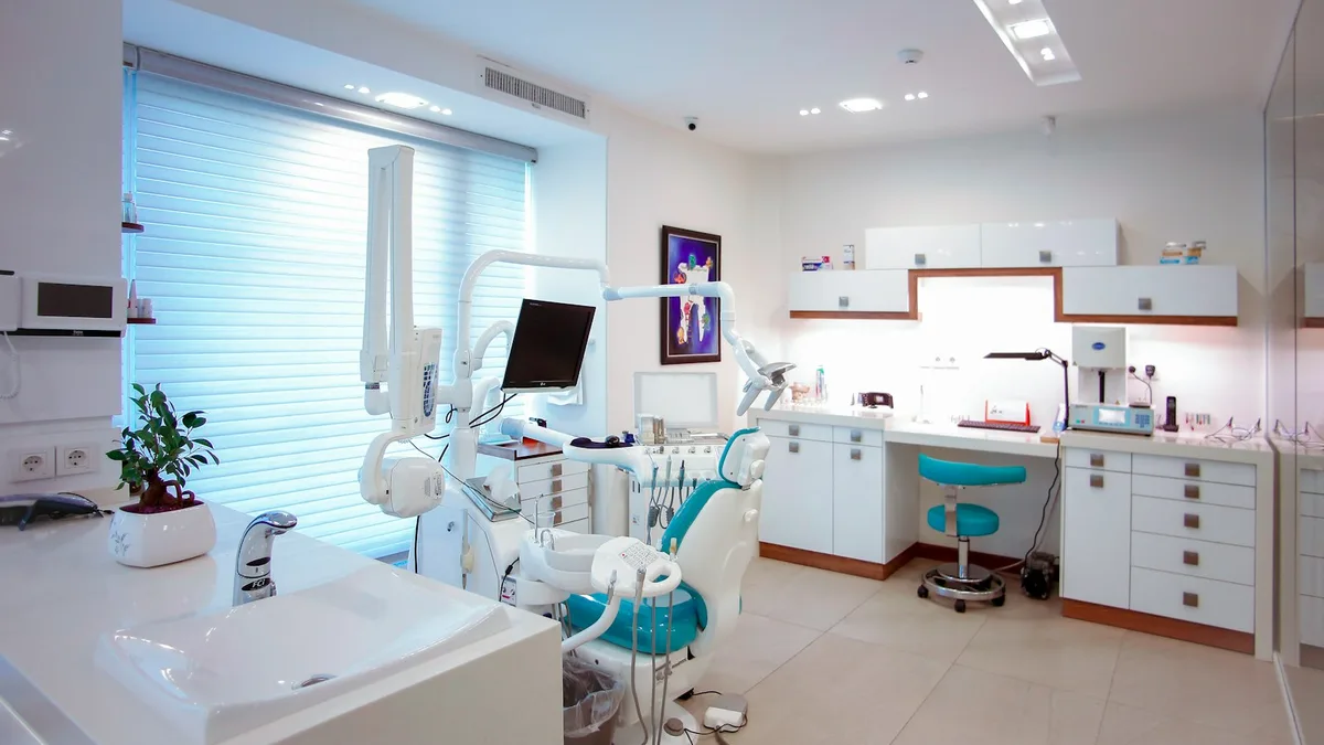 Dental team reviewing marketing performance and production numbers on a laptop dashboard inside a modern practice