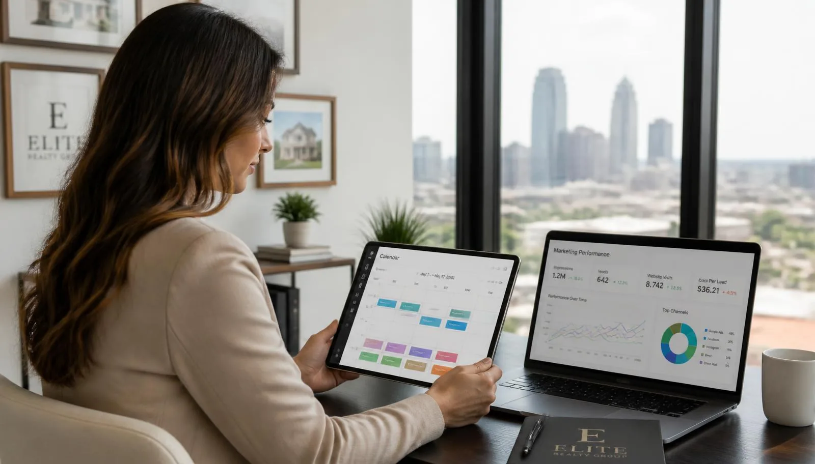 Real estate agent in a bright office reviewing a tablet booking calendar next to a laptop showing a marketing performance dashboard